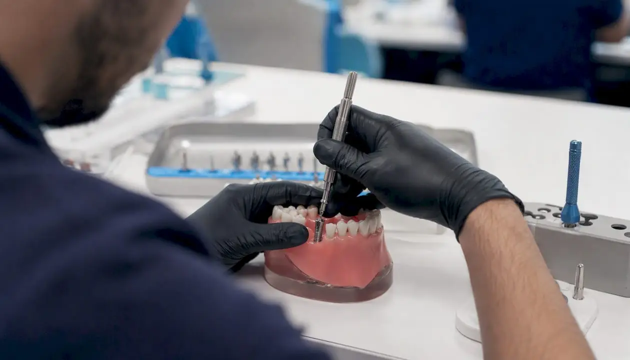 Dentist hands practicing implant placement on model